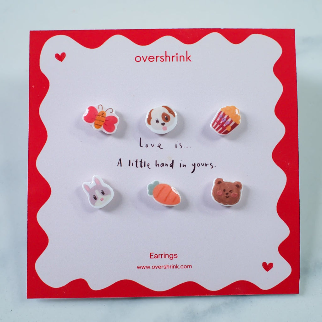 Set of small earrings on a 'overshrink' branded card with a red border.