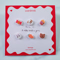 Set of small earrings on a 'overshrink' branded card with a red border.